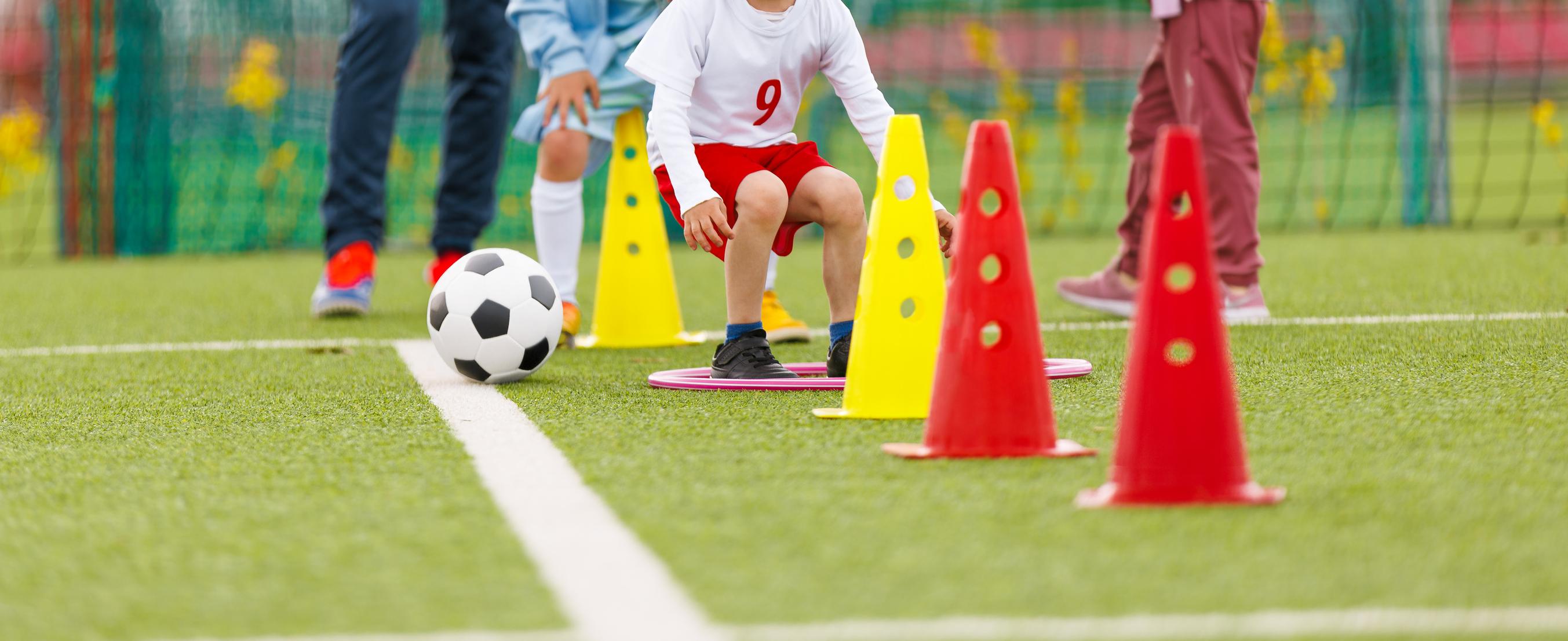 Young SJSA players running a cone dribbling drill